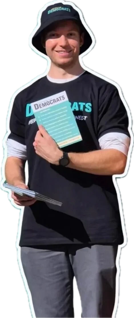 Ben in an Australian Democrats hat and T-shirt, holding how-to-vote cards